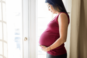 Hispanic pregnant woman with questions about adoption expenses, gastos de adopción